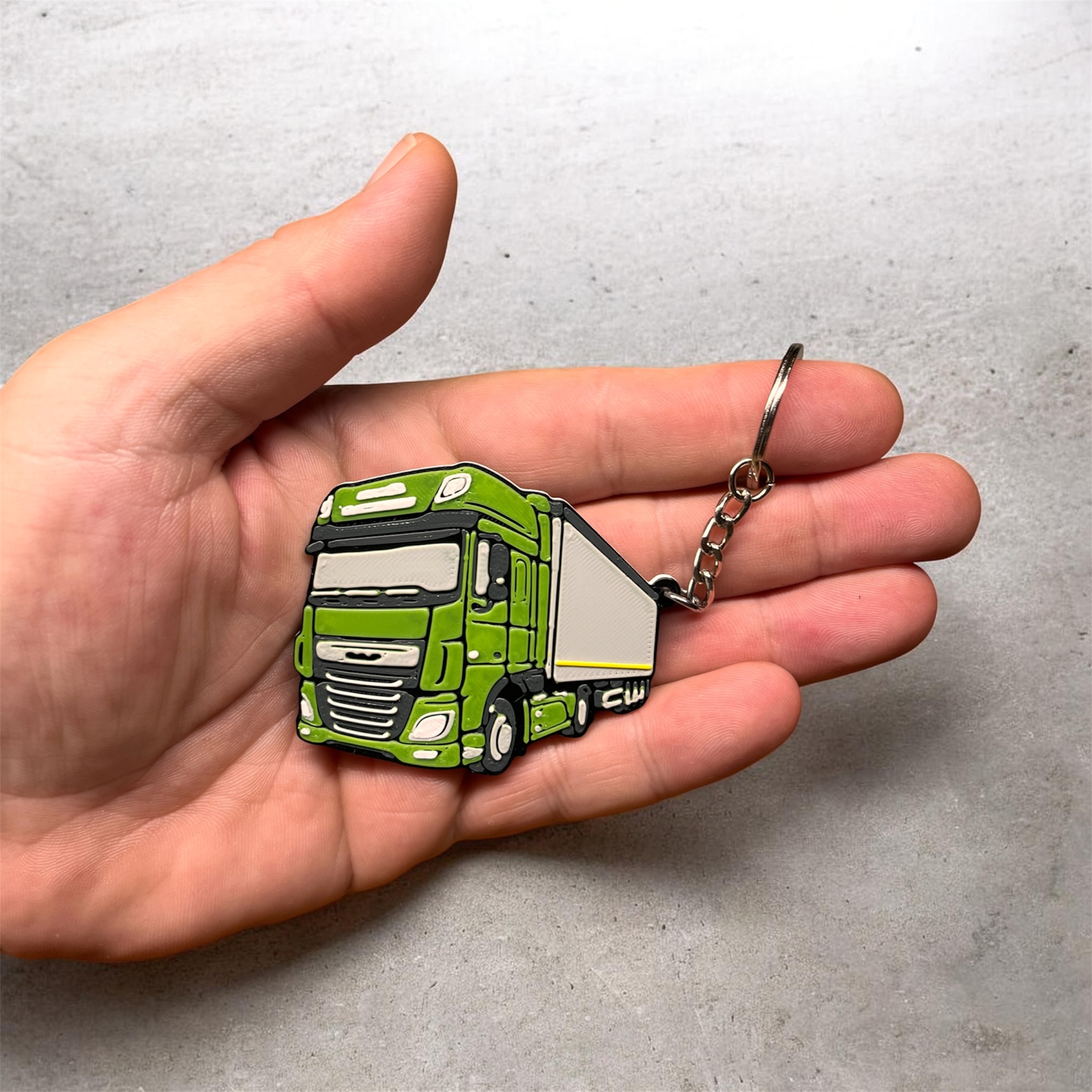 Zielony brelok DAF z naczepą dla Transport Duraj, trzymany w dłoni